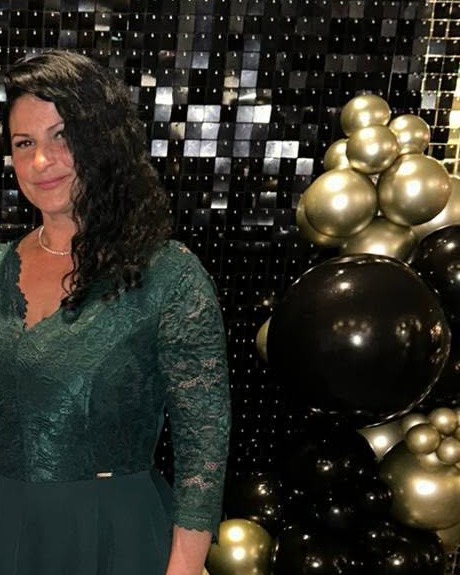 Rebecca, founder of Sun Therapy, in a green gown
